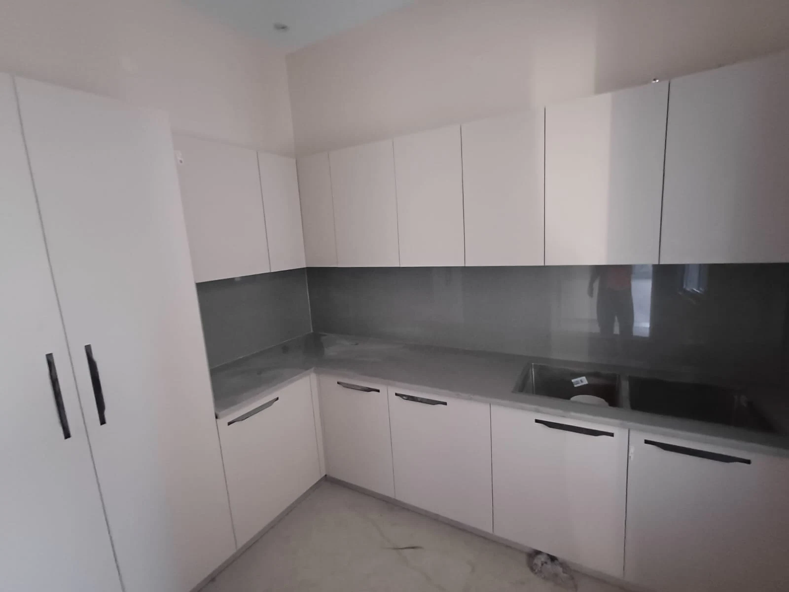 Minimalist handleless modular kitchen with tall pantry unit and profile lighting Patna