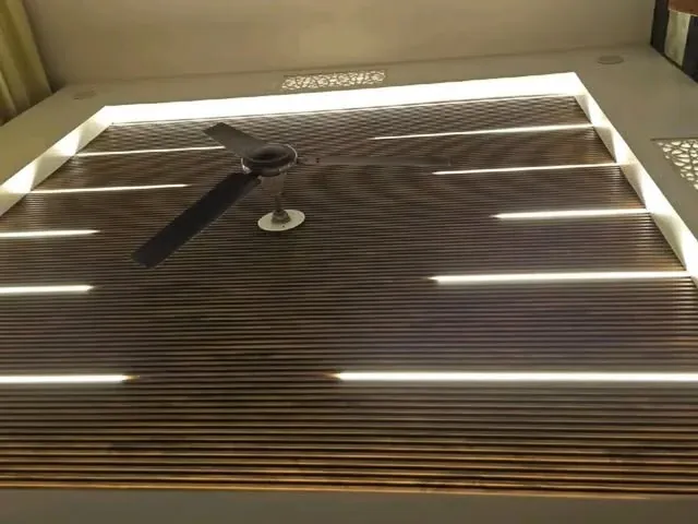 Fluted wooden false ceiling with linear profile LED lights by Avika Interior Patna